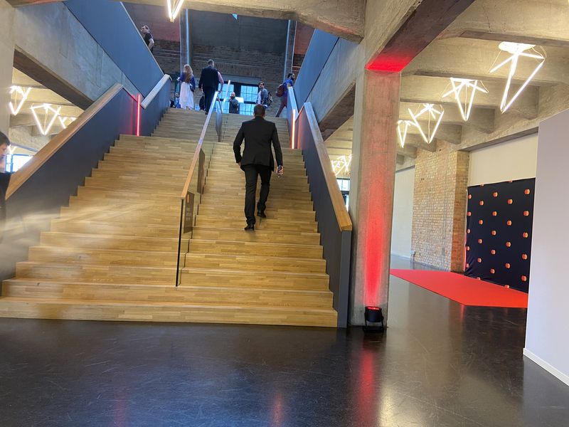 Breite Treppe mit rotem Teppich und Lichtinszenierung als Gästeweg zu einer Veranstaltung